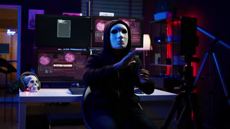 hacker group member wearing anonymous mask filming video threatening government