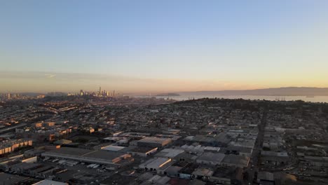 Un-Tranquilo-Dron-Se-Retira-Lentamente,-Brindando-Una-Perspectiva-Encantadora-Sobre-Un-Vecindario-De-San-Francisco-Con-El-Telón-De-Fondo-De-Los-Edificios-Del-Centro-Inmersos-En-El-Brillo-Dorado-De-La-Mañana.