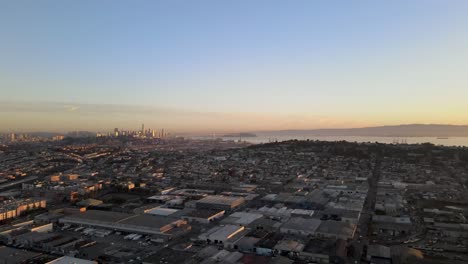 A tranquil drone retreats slowly, providing an enchanting perspective over a San Francisco neighborhood with the backdrop of downtown buildings immersed in the morning&#039;s golden glow