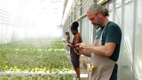 Middle-Age-Man-Working-on-Tablet-in-Flower-Greenhouse