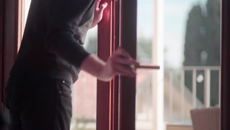 joven abre la puerta de la terraza