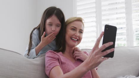 madre e hija teniendo una videochat en el teléfono inteligente en casa