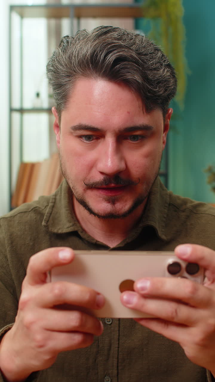 Middleaged man celebrates smartphone game jackpot pumps arms yelling woo victory excitement triumph