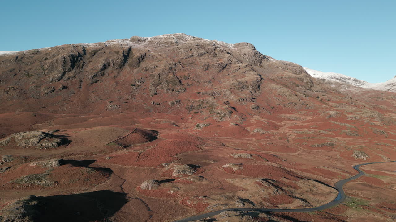 와스데일 레이크 디스트릭트(wasdale lake district uk) 아래 구불구불한 도로가 있는 산악 겨울 풍경 위로 높이 날기