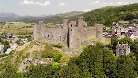 harlech castle in north wales, gwynedd, uk, shot by drone to show proximity of the castle against the town and coast