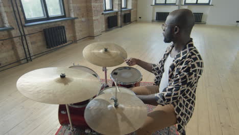 african american drummer playing drumset