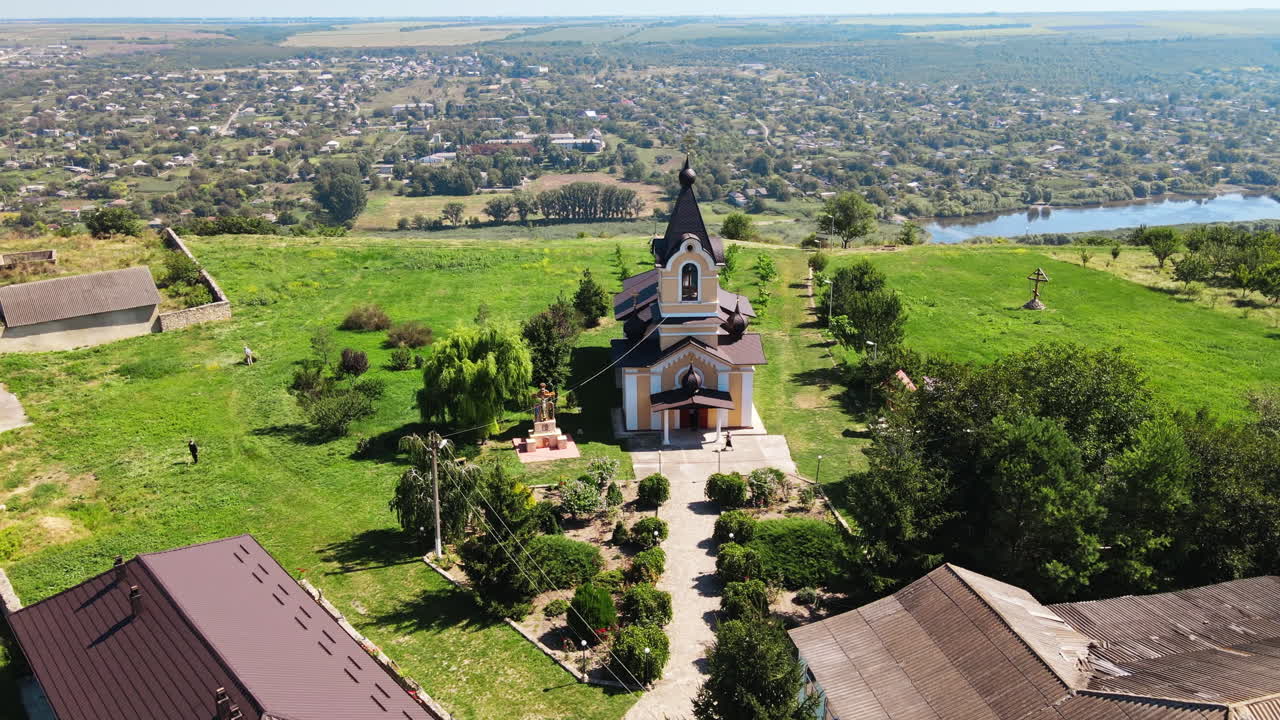 Aerial drone view of a church, located near a valley with river in Moldova. Village on the background