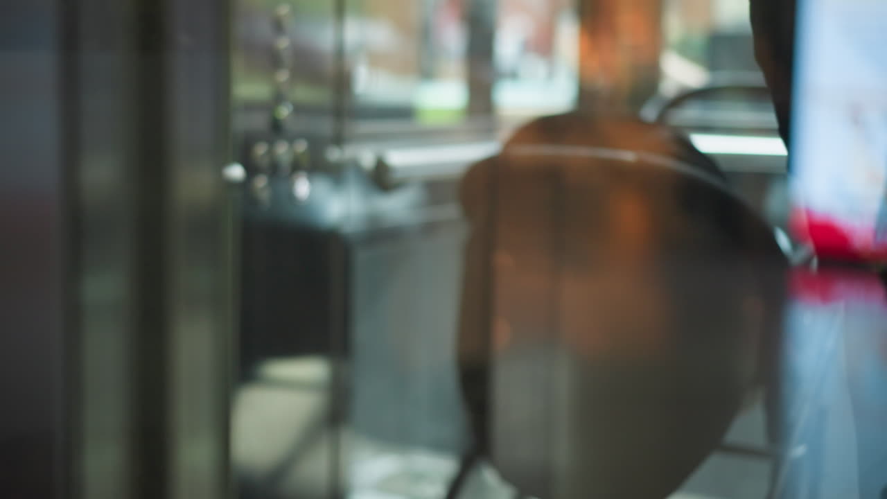 소매점에서 움직이는 쇼핑 카트 바의 클로즈업, 반사와 함께 흐릿한 창을 통해 포착, 유리 위에 누군가의 반영과 함께 바쁜 쇼핑 경험을 전달