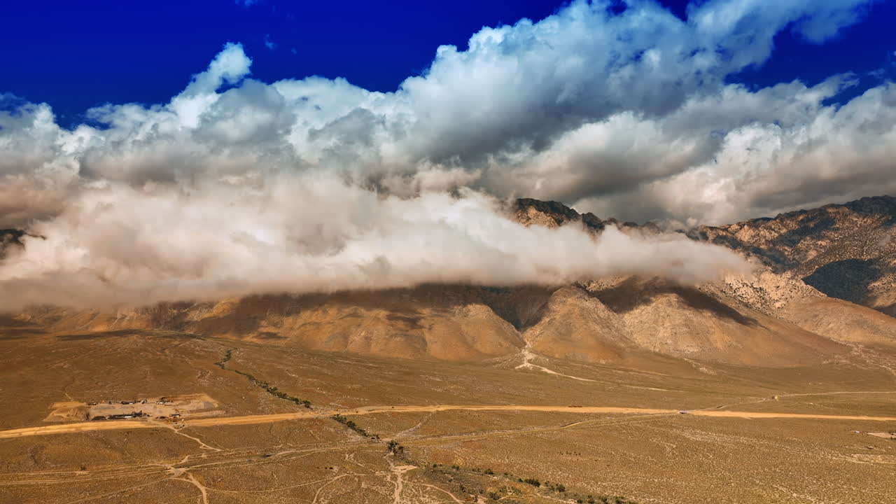 Massive cloudscape coating the tops of the mountains in Death Valley. Beautiful view of the desert surrounded by rocks. Top view.