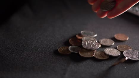 hands counting coins on dark background medium shot