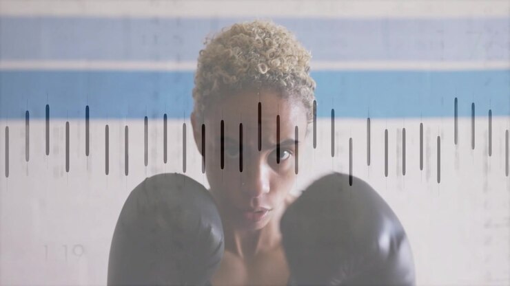 Woman boxer raising guard and jabbing lens in fitness graph tracking data aligning with gloves