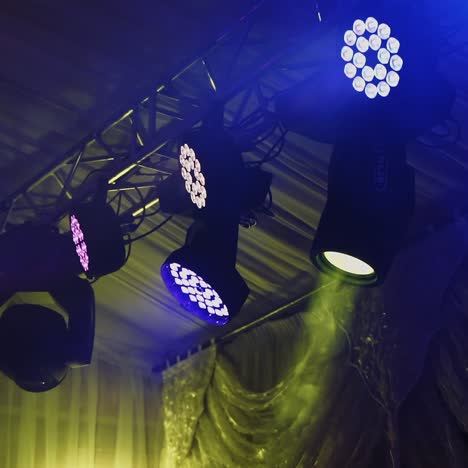 colored spotlights in the nightclub. spotlights above the stage. lasers of a farm spinning and shimmering brightly.