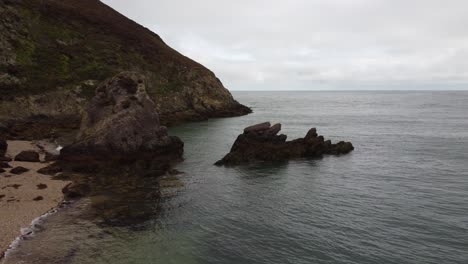 Orbit-Shot-Of-Big-Rock-Formation-On-Porth-Wen-Beach,-United-Kingdom