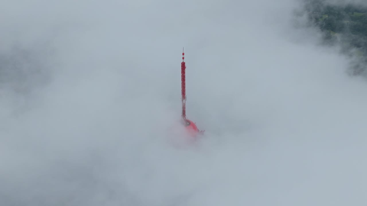 Prachtig vogelperspectief van de iconische Turyapada-toren op Bali. De rode communicatiestructuur die oprijst uit een zee van dichte, witte mist.