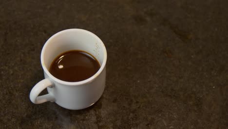 Sugar-being-added-to-coffee-with-metal-spoon,-close-up