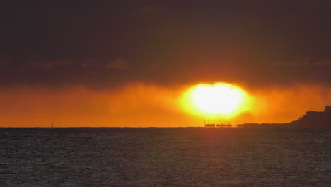 sun on ocean horizon with dark clouds