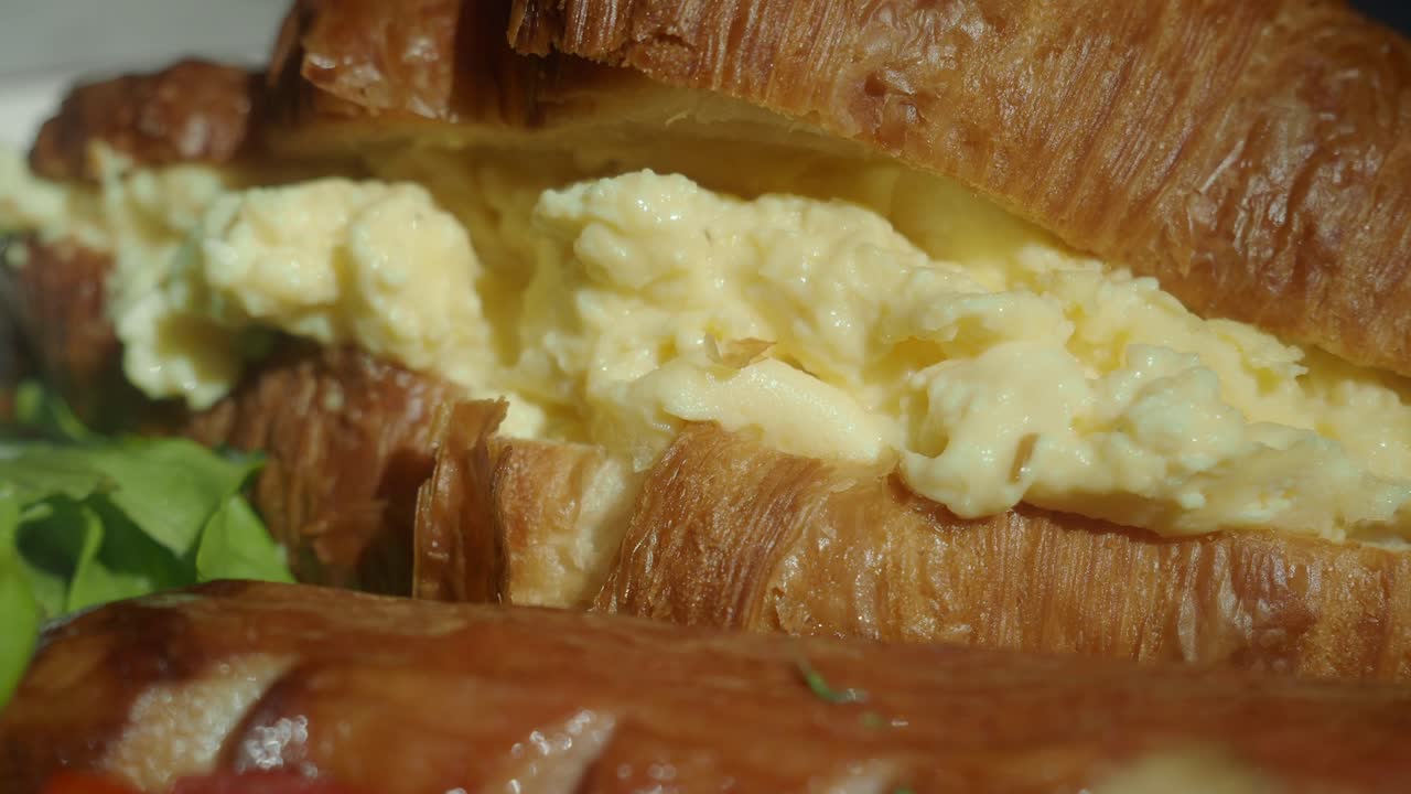 Croissant sandwich with scrambled eggs and sausage