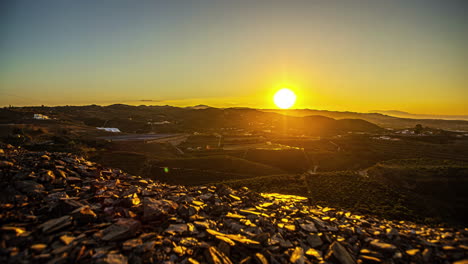 amanecer sobre un terreno de campos plantados y montañas