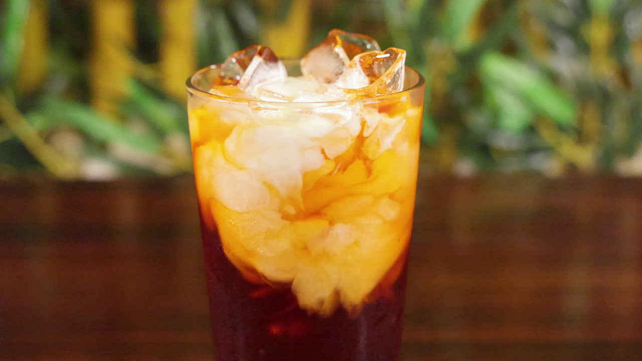 전통적인 아이스 타이 밀크티에 신선한 크림을 붓고 슬라이더 슬로우 모션 4k를 닫습니다.