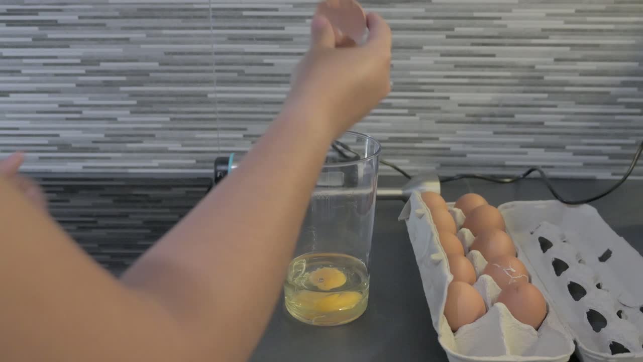 romper un huevo para hacer mayonesa casera