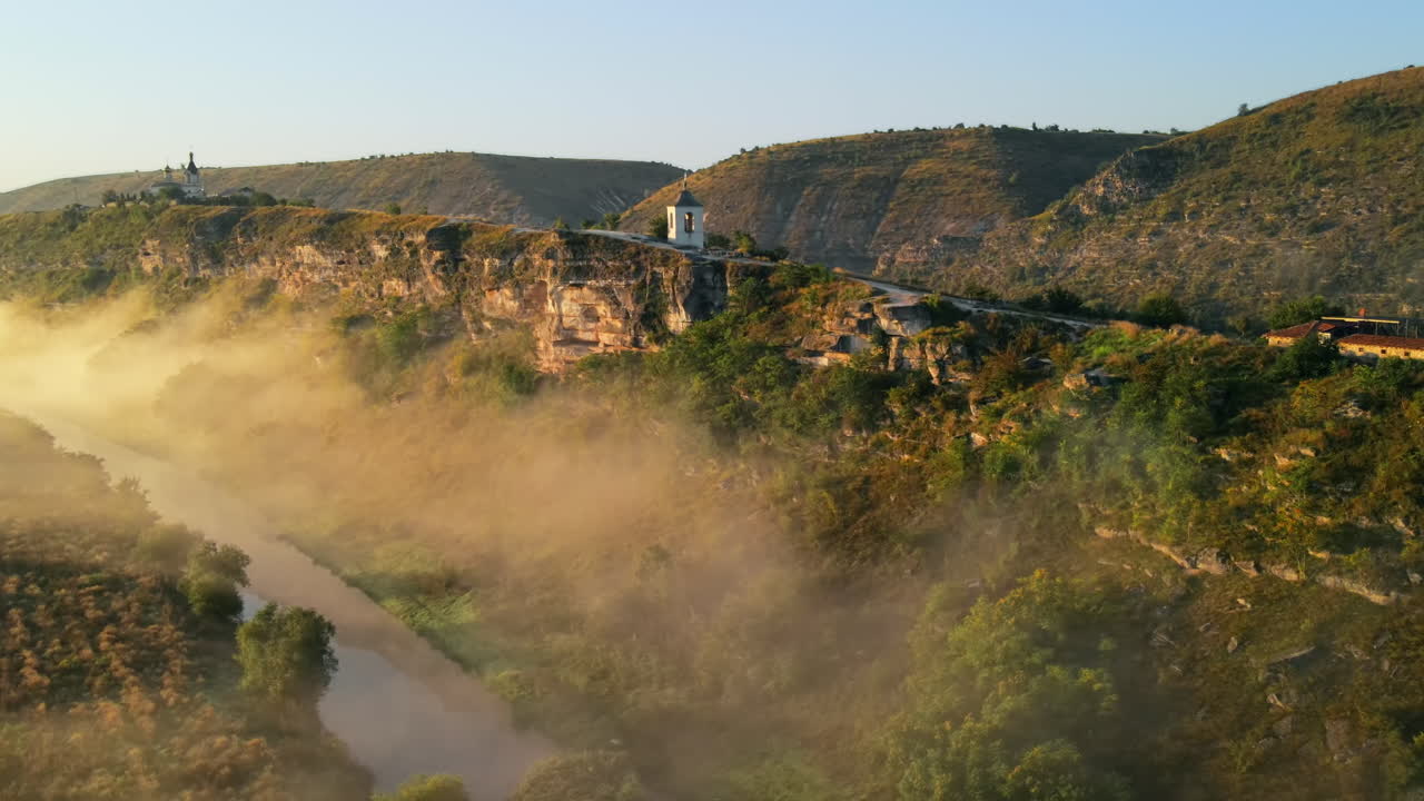 Aerial drone view of the Old Orhei at sunset. Valley with river and fog, monastery located on a hill in Moldova
