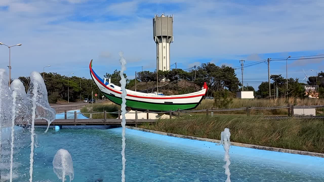 Boat alluding to ancestral art at the entrance roundabout of Praia da Tocha, a tribute to fishermen and X&aacute;vega art, with water fountains