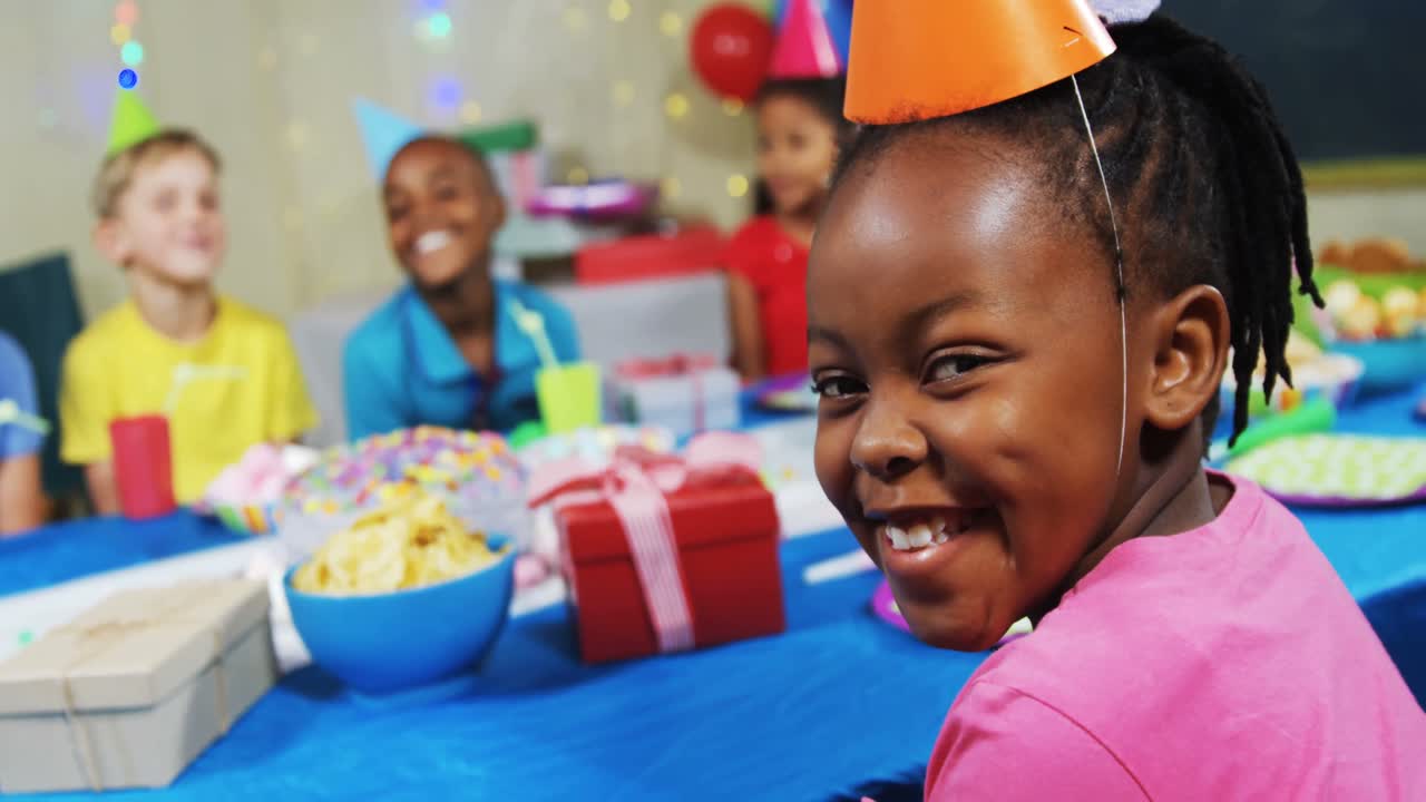 Portrait of smiling girl sitting with friends at table during birthday party 4k