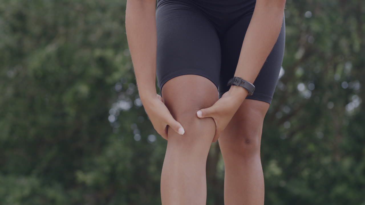 아슬레틱 한 소녀 가 무 ⁇  을 통증 으로 마사지 하고 있다