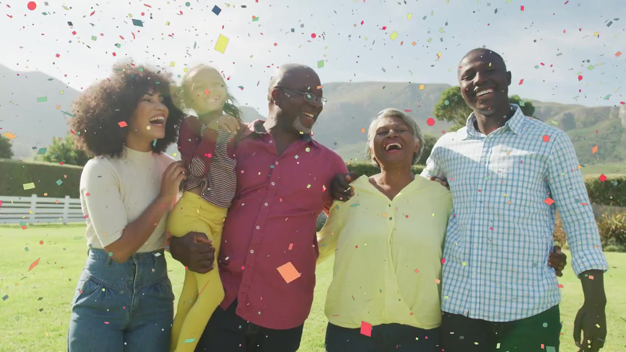 Multi-gen family on lawn, confetti falling above, holding gold balloon, celebrating marketing