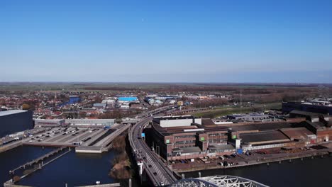 Vehicles-Driving-In-The-Road-Towards-Arch-Bridge-Over-Noord-River-In-Hendrik-Ido-Ambacht,-Netherlands