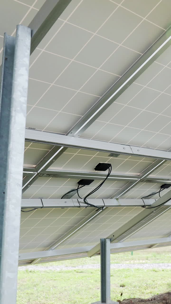 Back side view rows array of polycrystalline silicon solar cells or photovoltaics in solar power plant. Vertical video