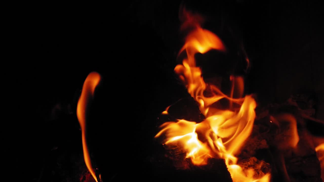 Fiamma ardente nel camino su ciocchi di legno