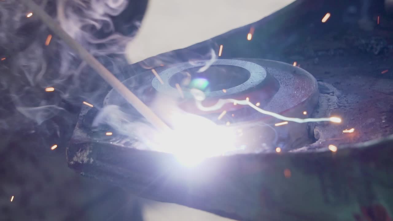 Electrode Welding a Piece of Steel Making Sparks and Smoke - Close Shot Slowmotion