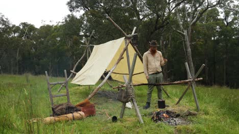 El-Bosquimano-Australiano-Fuma-En-Pipa-Junto-A-Un-Campamento-Pionero-De-Aspecto-Histórico