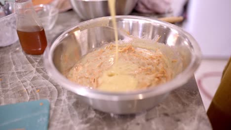 cocinero de cultivos agregando ingredientes en un tazón con masa