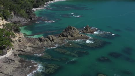 antena de la pintoresca costa rocosa con impresionantes aguas azules en la costa de nueva zelanda