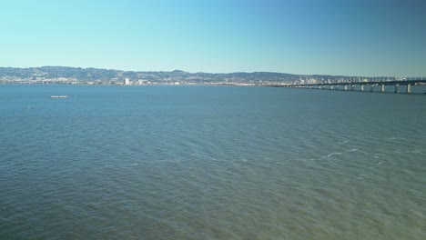 pan drone shot of san francisco-oakland bay bridge with pacific ocean in california, usa