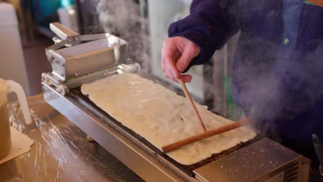 Nahaufnahme-Einer-Person,-Die-Auf-Einer-Heißen-Platte-Traditionellen-Pfannkuchen--Oder-Crêpe-Teig-Knetet