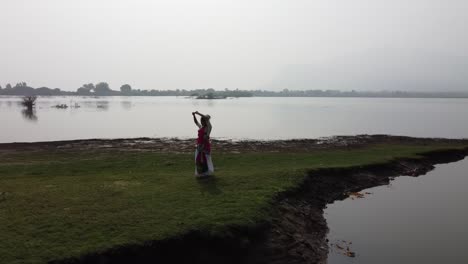 Una-Bailarina-De-Bharatnatyam-Que-Muestra-Una-Pose-Clásica-De-Bharatnatyam-En-La-Naturaleza-Del-Lago-Vadatalav,-Pavagadh