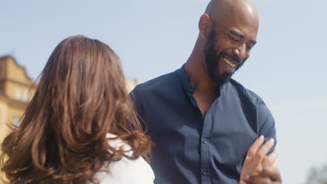 Close-up-of-a-happy-interracial-couple-dancing-salsa-in-the-old-town-street