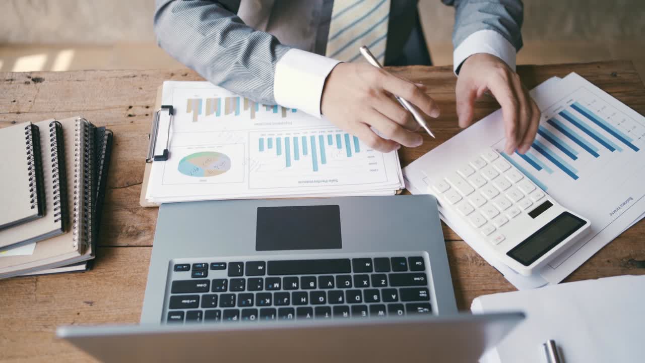 hombre de negocios que trabaja en una oficina de escritorio con análisis de estadísticas de gráficos de marketing, concepto de sistemas financieros e fiscales.