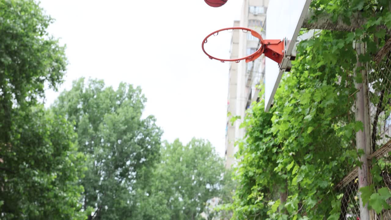 Child and adult playing basketball outdoors