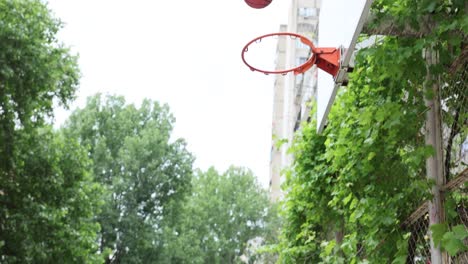 child and adult playing basketball outdoors