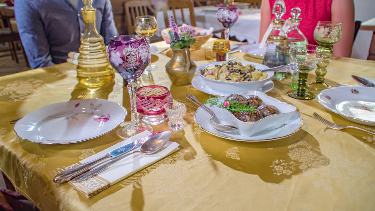 Restaurant table decorated with beautiful cutlery and waiter serving delicious food. Close up