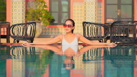 modelo femenino reflejo en el agua de la piscina, fondo del hotel slomo