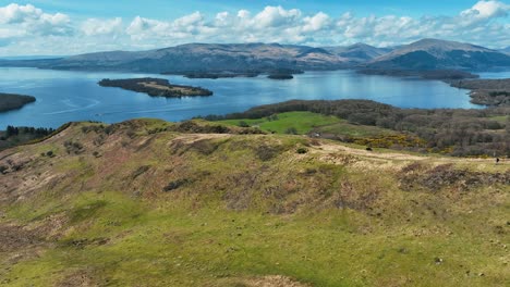 aerial over conic hill towards loch lomond on sunny day, scottish hills
