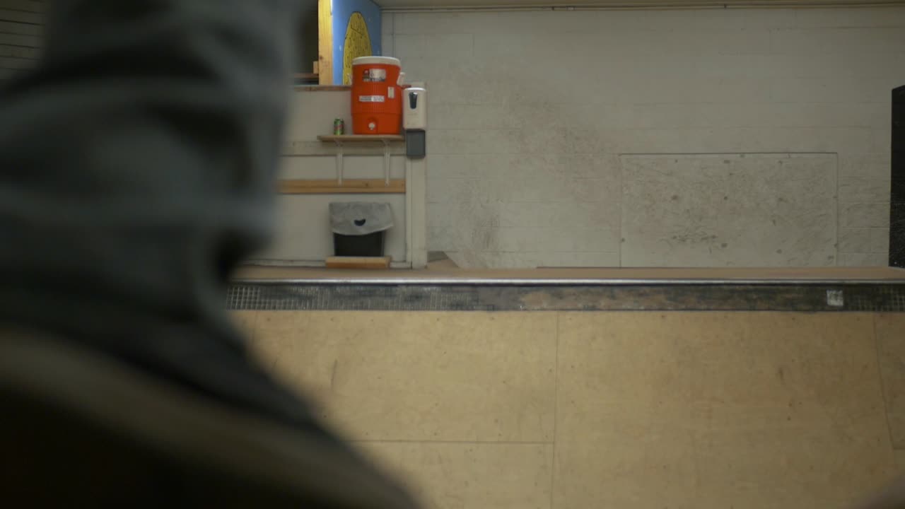 skatepark cubierto halfpipe con un patinador de patinaje