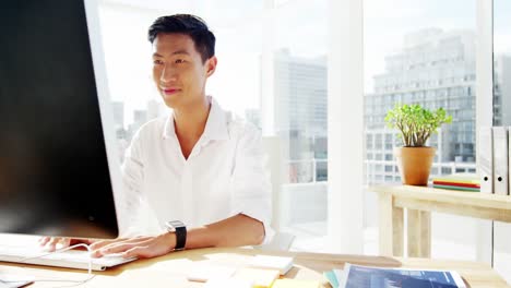 a smiling man working on his computer