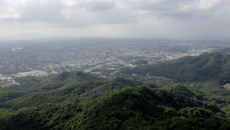 antena: ciudad de guangzhou en la ladera de la montaña china, vista desde baiyun shan