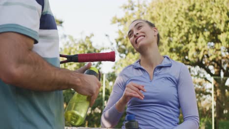 Video-De-Una-Feliz-Pareja-Caucásica-Bebiendo-Agua-En-La-Cancha.